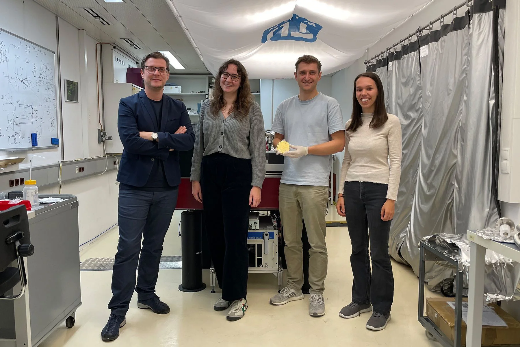 Four members of the Invacuo team standing in the laboratory at TU Wien